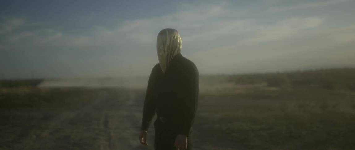 A car drives past a person with a gold hood