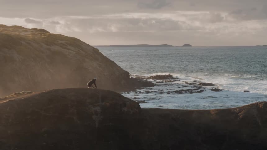 A bicyclist rides on a hilly coast