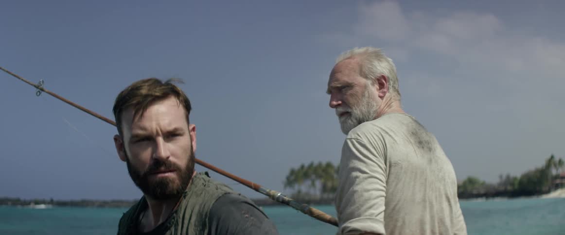An elderly man watches as his fishing companion stares into the distance