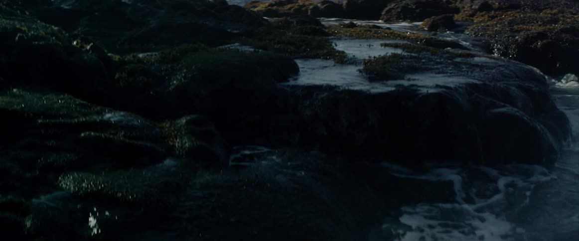 Waters coming ashore on a rocky beach