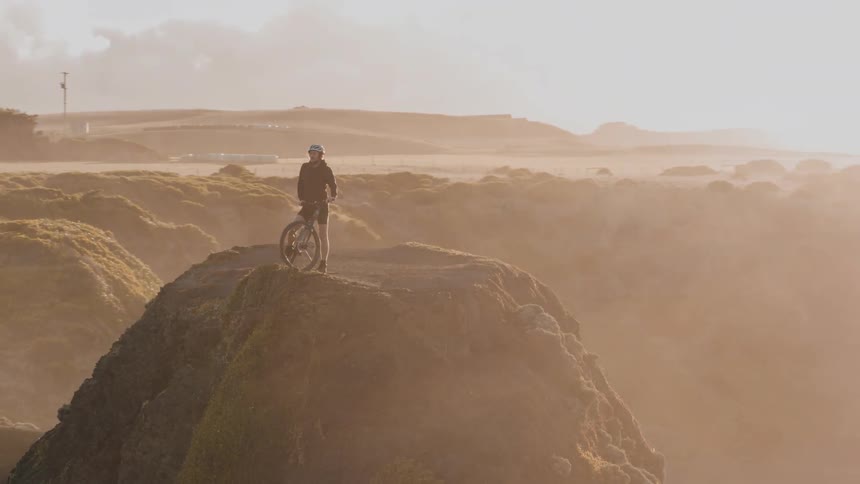 A man is on the edge of a mountain on his mountain bike