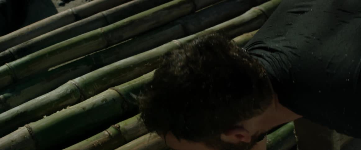 A man leans down building something