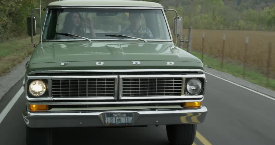 Man and woman smiling and talking while driving in truck
