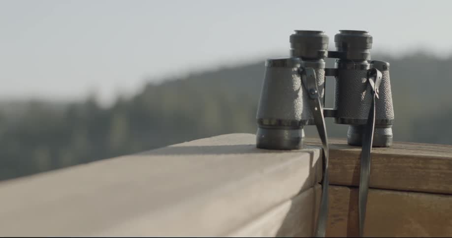 Binoculars sit on a ledge in the daytime