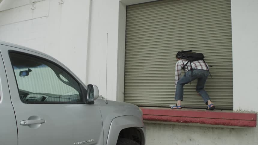 A man with a backpack jumps onto a loading dock