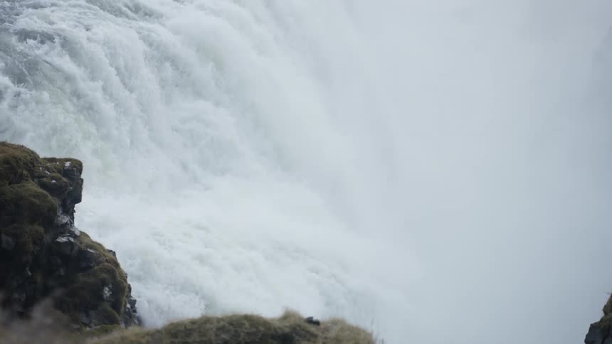 Water from the waterfall is gushing downhill