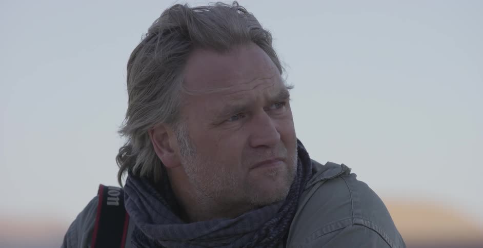 A man looks back and forth on a windy day