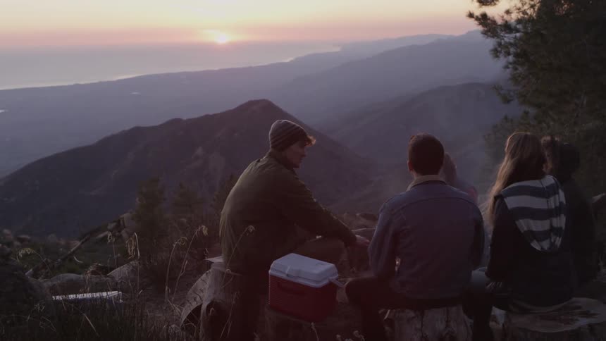 Four people have a picnic on a mountain