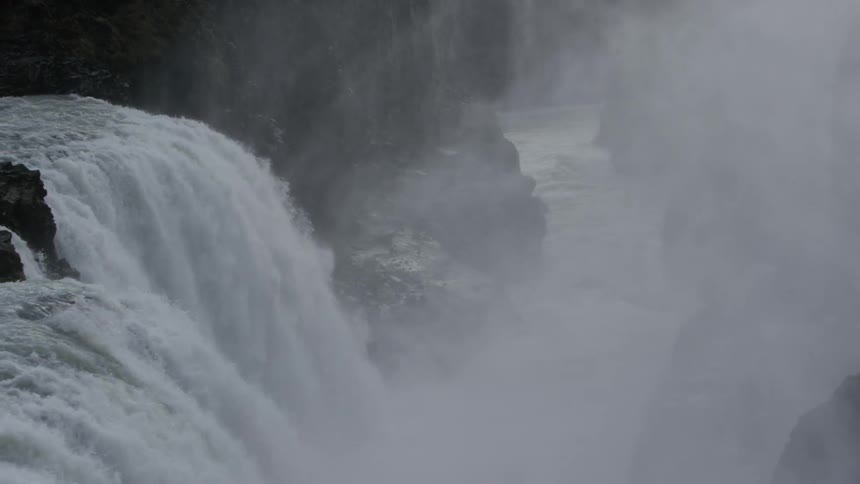 Water from the waterfall falls downhill and creates mist