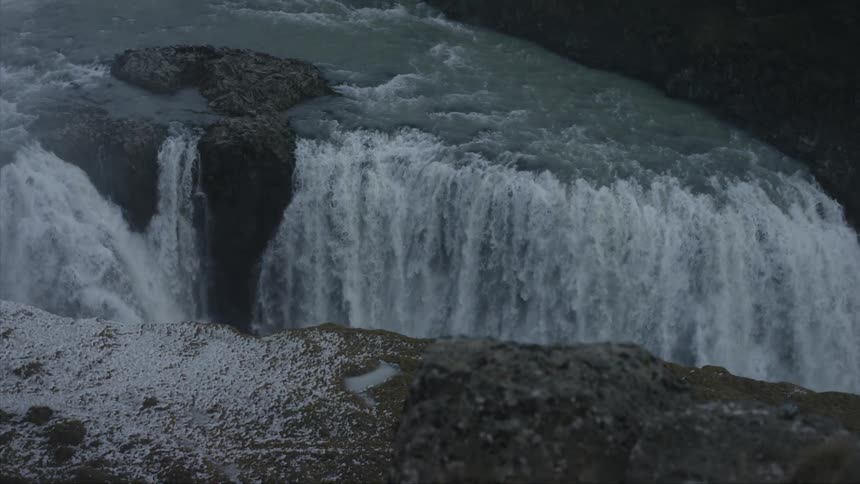 A giant waterfall tumbles over a steep drop off