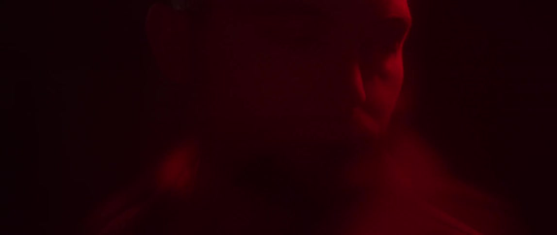 A man stands in front of strobe lights