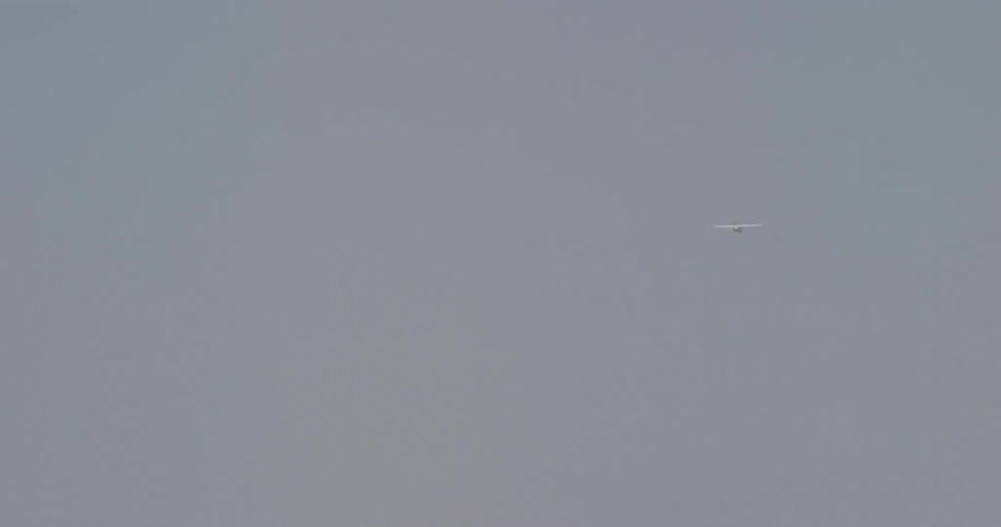 An airplane flies in a clear sky