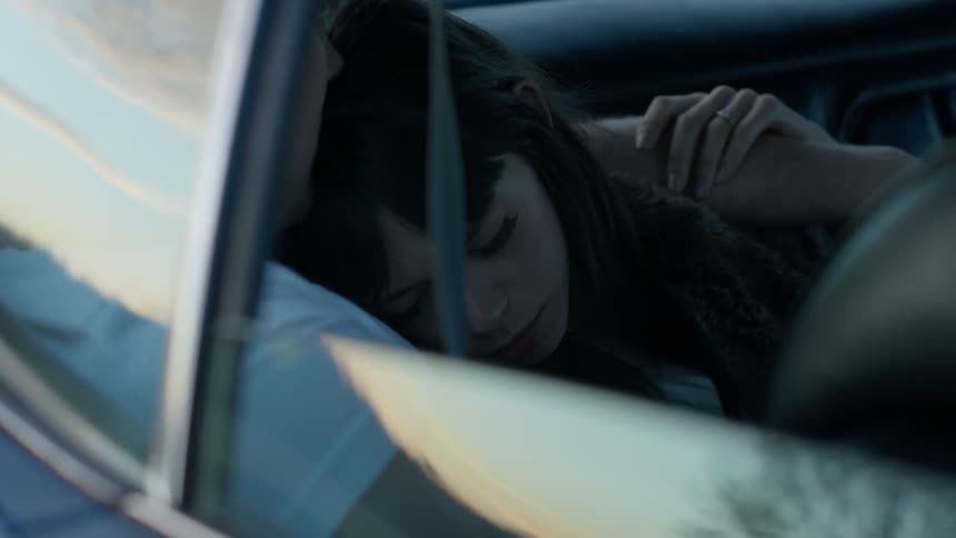 Mother holding child in back seat of vehicle