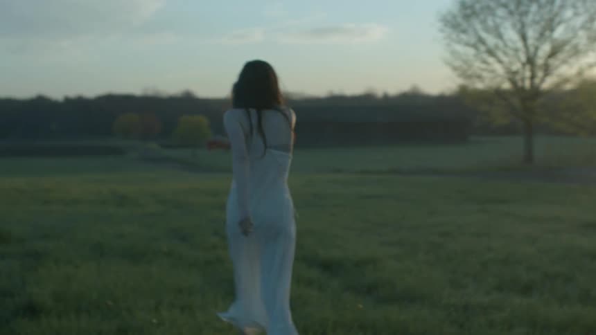 Woman striking a man as he tries to control her before she breaks away and walks away from him in the country at sunset