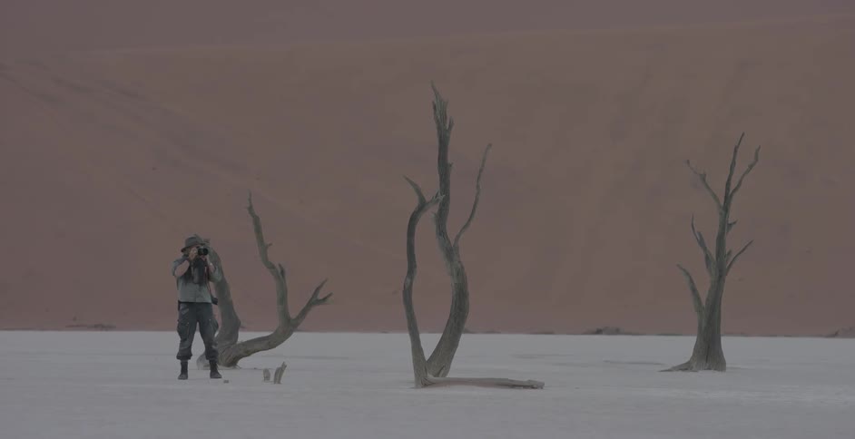 A man is taking photographs in the desert