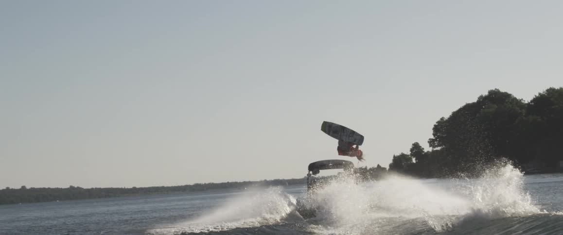 A person skis behind a boat on a lake