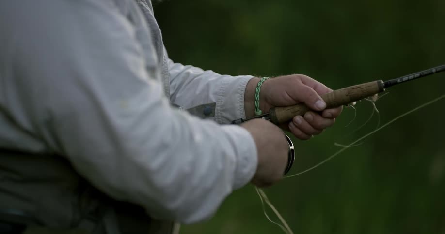 A fisherman reels in a fishing line