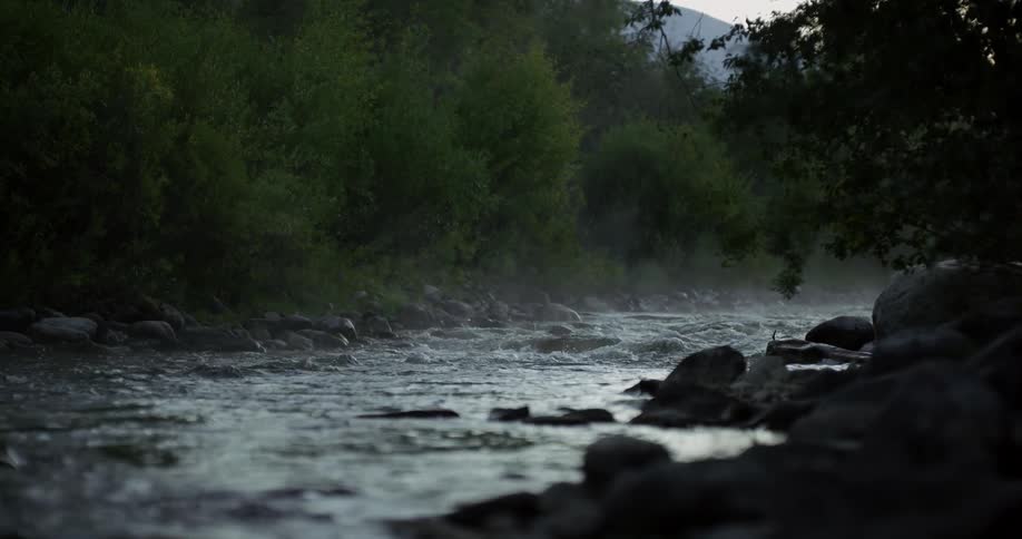 The water slowly splashes over the rocks in the stream