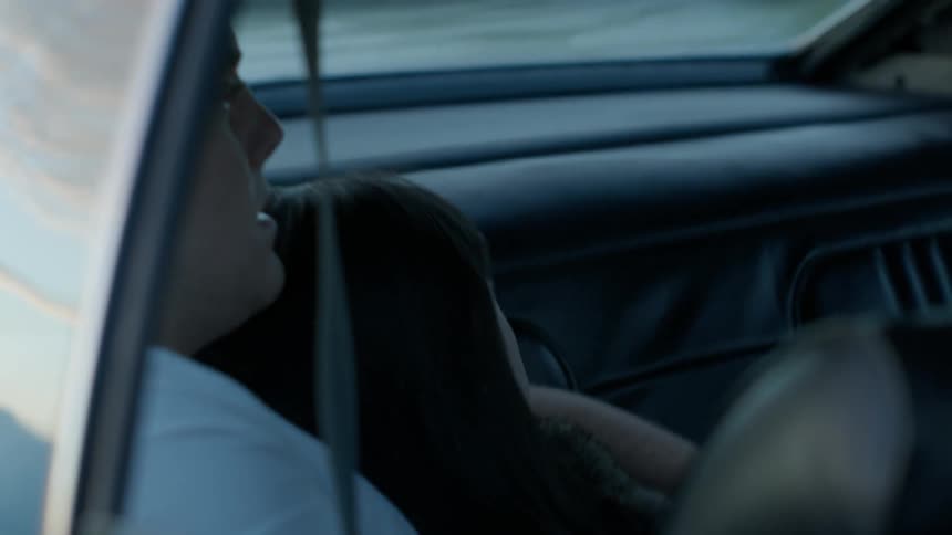 Two people lay in the back of a vehicle