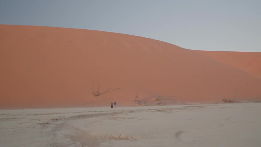 Two people walk in the desert