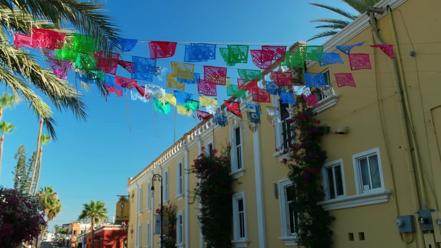 Colorful flag decorations strung across a street flap in the breeze