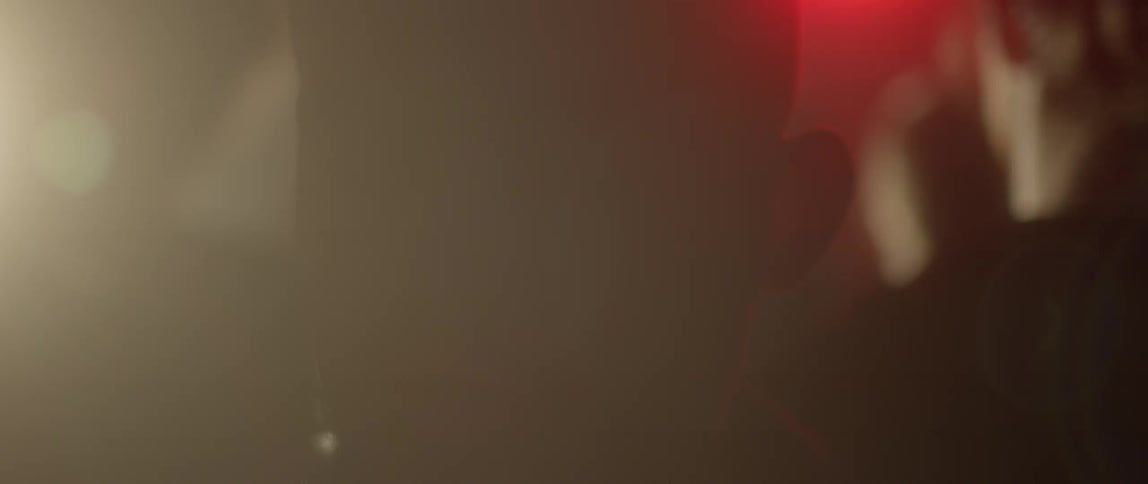 Colored lights flash around a man walking in a crowd