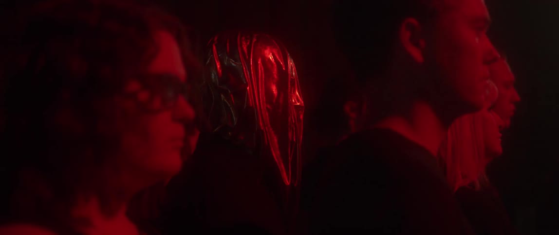 People stand still in a room as lights strobe