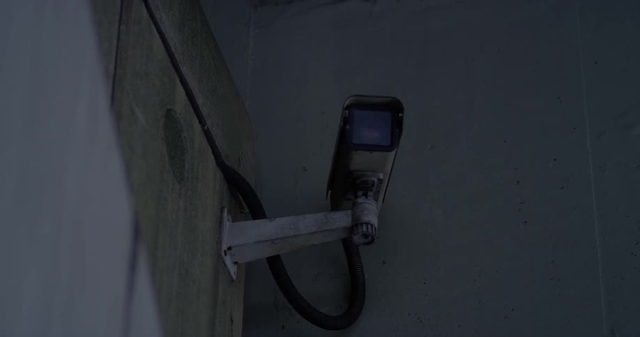 A security camera is attached to the outside of a building