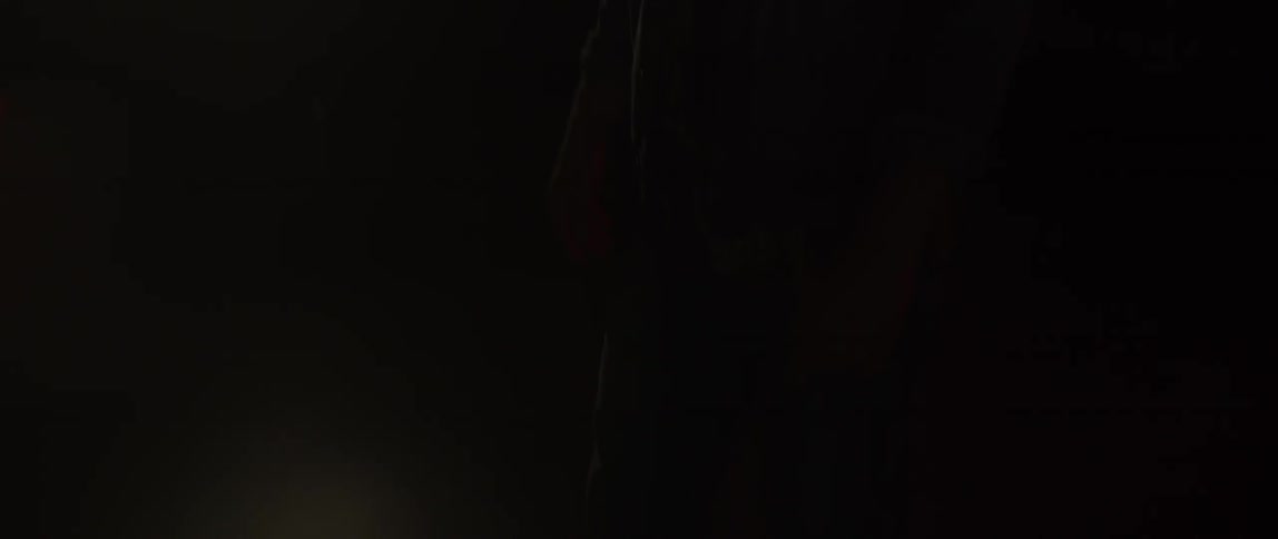 A man walks on the floor while lights strobe around