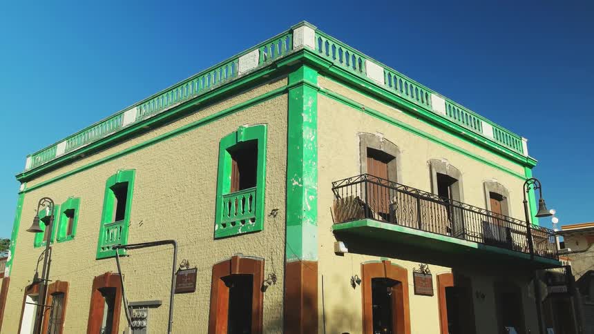 Lamp posts hang outside a bright green building