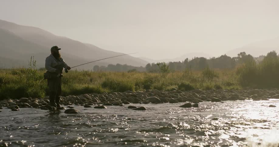 A man is fly fishing in the creek