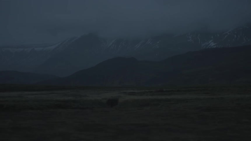 Majestic mountains in the distance shrouded by low-hanging clouds at dawn