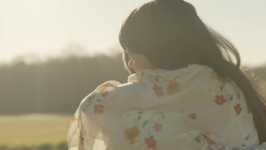 A man holds on to a woman that is hugging and kissing him