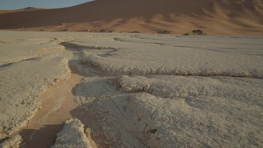 A dry riverbed cuts a channel through a desert