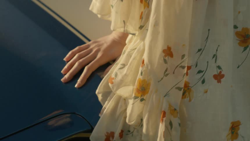 A person is leaning on a car