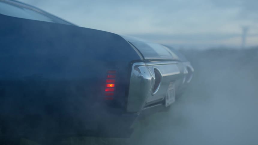 Exhaust streams out of a car revving its engine