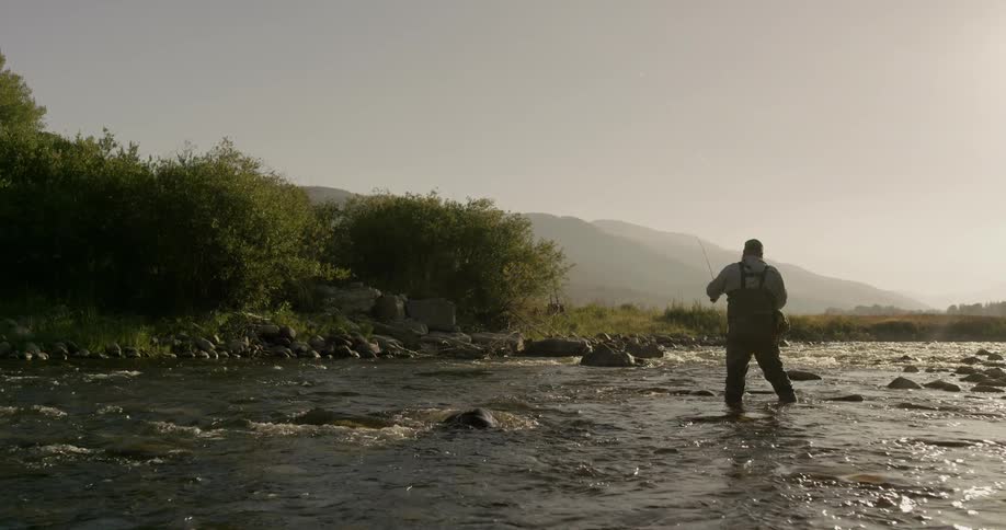 A man fishes in a stream