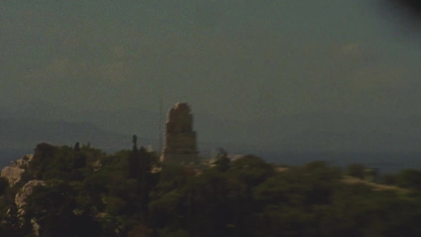 A landmark sits atop a tree lined mountain
