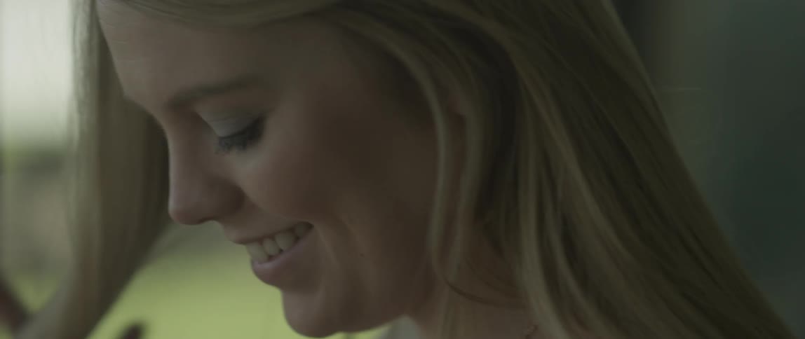 A woman smiles and twirls her hair