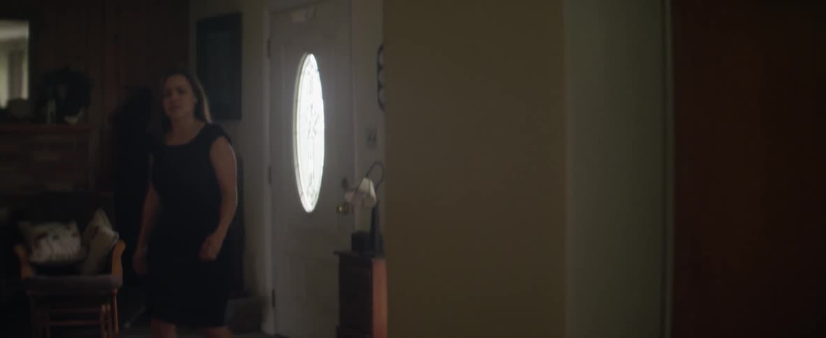 A woman enters a house and closes the door
