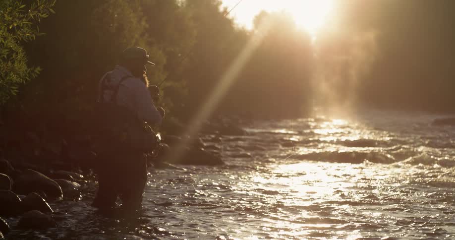 A fisherman fishes in a stream