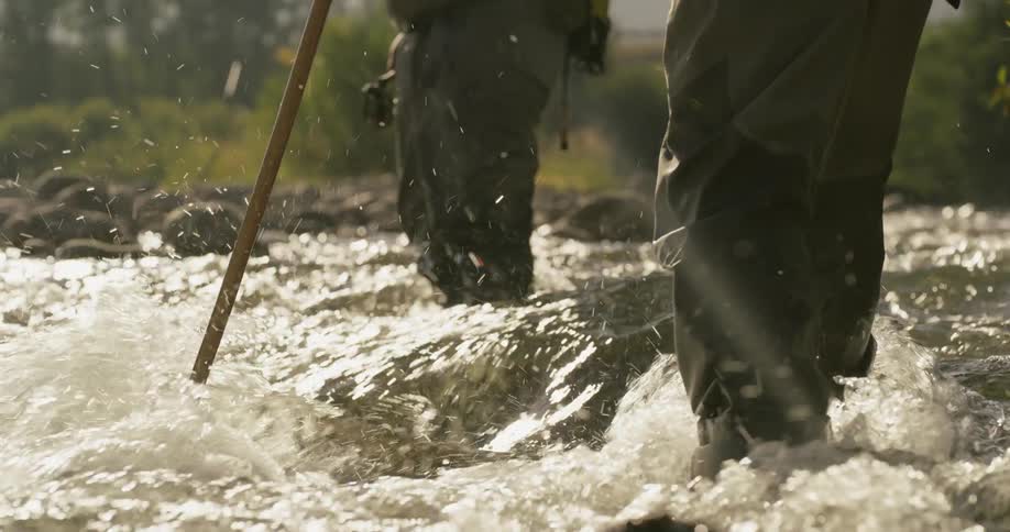 A man fishes in fast flowing water