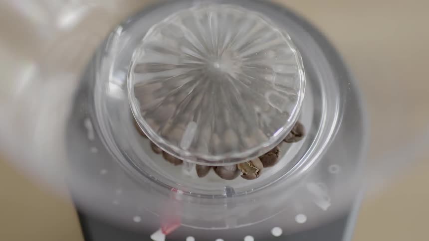 Top view of a coffee grinder with beans grinding