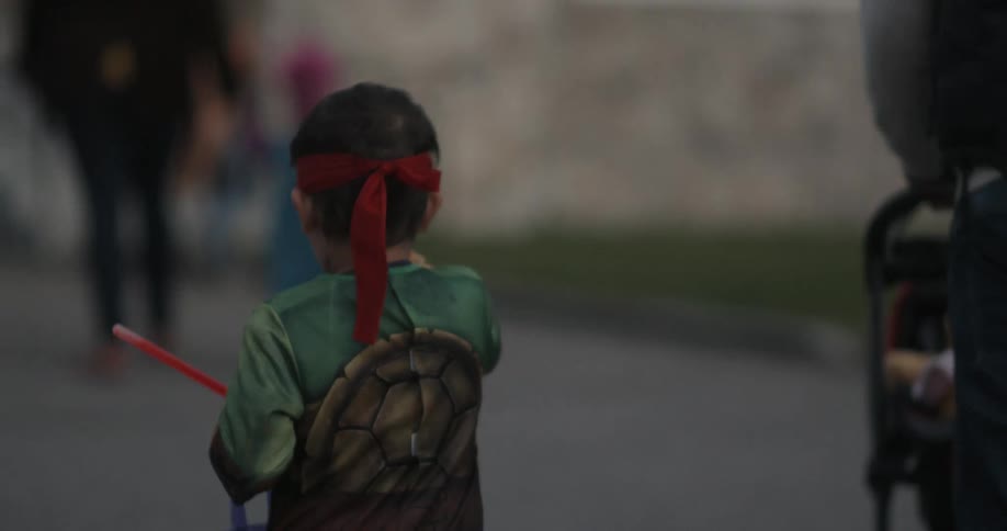 A young child in costume goes trick or treating