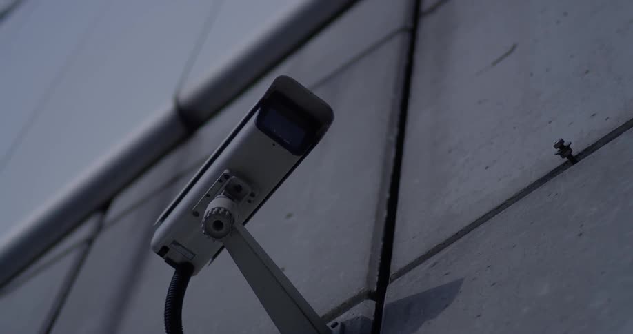 A security camera is attached to a concrete wall