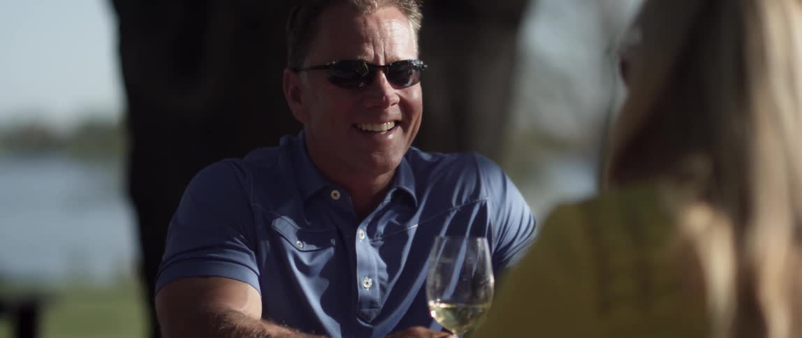 A man and woman have a conversation with glasses of wine