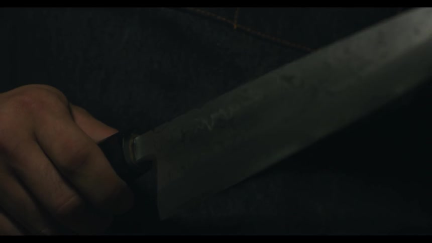 A large knife is held in a hand