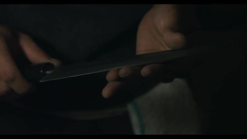 A man is testing the sharpness of a knife