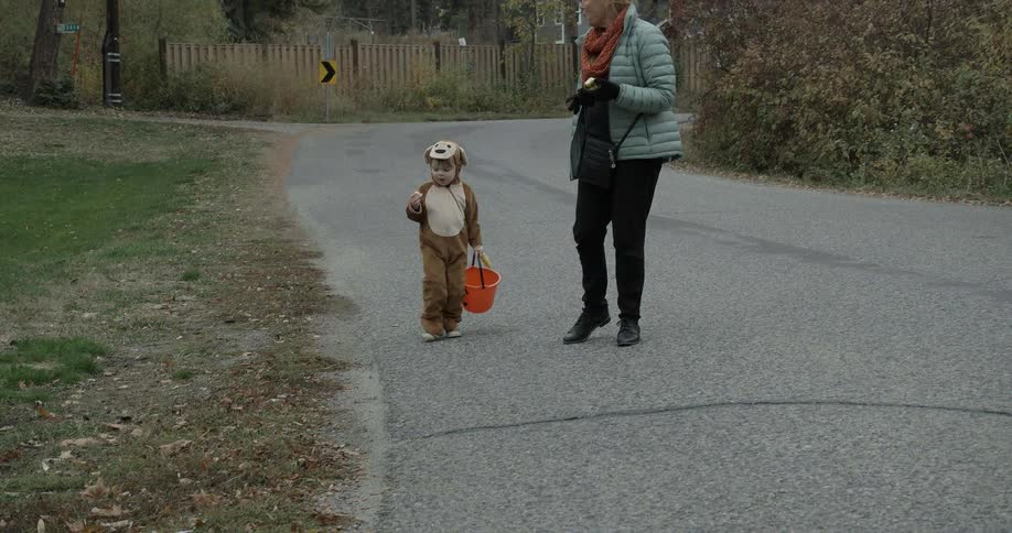 A woman is walking with a child in a costume