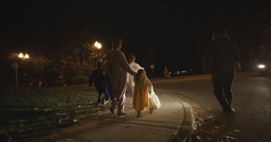Adults walk children in costume to trick or treat